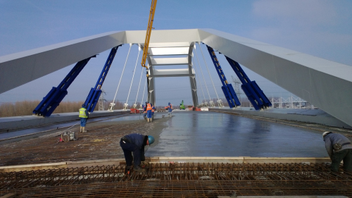 The concrete being poured onto the composite panels of the Uyllander bridge.