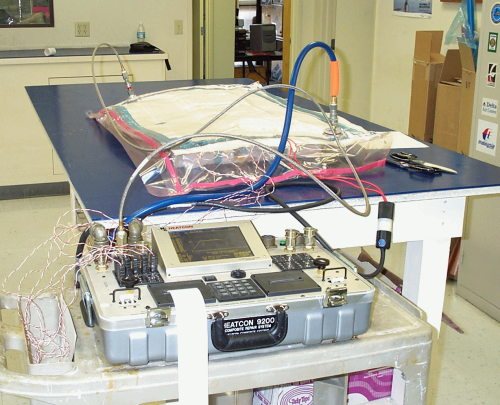 A 'hot bonder' can be used to cure and monitor the curing of the composite repair 'patch'. These machines typically include a heater and a vacuum source. 
(Picture courtesy of Abaris.)