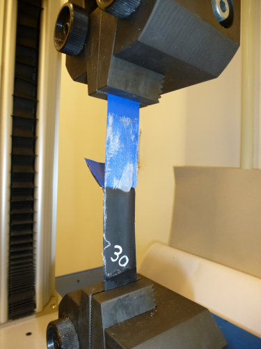 Peel testing of an adhesive for the lamination of elastomeric materials.