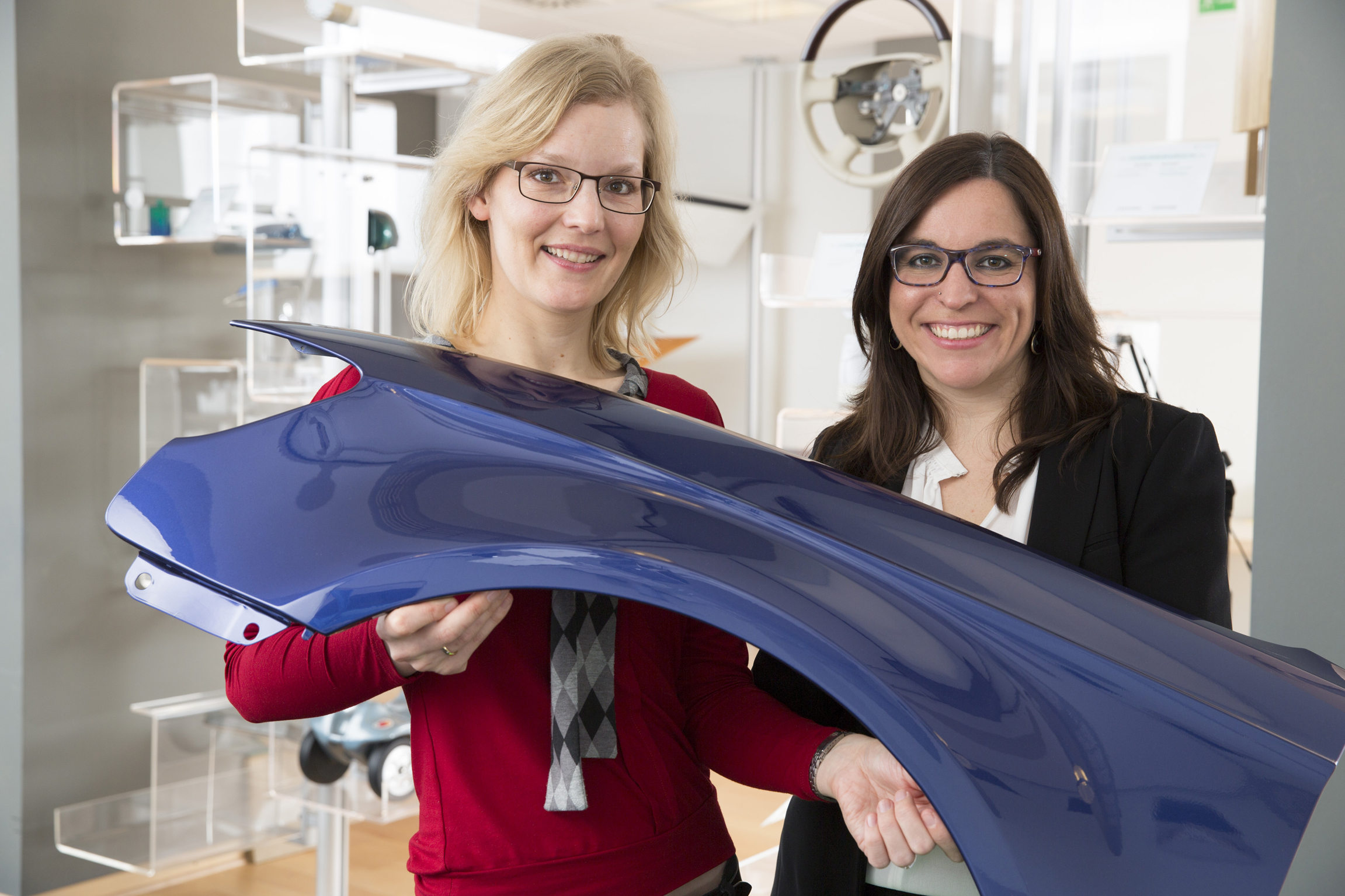 Dr. Gesa Behnken (left), global head of new technologies, and Dr. Berta Vega Sánchez, marketing manager in the coatings, adhesives, specialties business unit of Bayer MaterialScience, present a coated car body part.