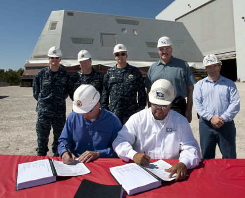 The signing of the documents signifying the delivery of the Zumwalt (DDG 1000) deckhouse (seen in background) to the US Navy.