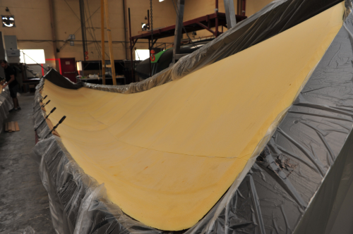 Dry carbon fabrics and pre-bent foam are laid into the half hull moulds and then infused. Vacuum infusion
technology ensures high fibre volume ratios and reduces weight variation.