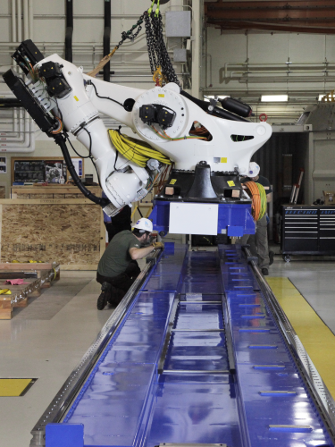 The 21-foot tall robot arm placed on the track. The robot head will make large composite pieces by sliding up and down the track laying down epoxy and carbon fibers in precise patterns.
Photo courtesy: NASA/David C. Bowman