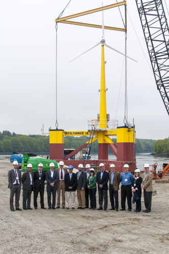 Project supporters and members of the DeepCwind Consortium stand with the VolturnUS 1.8 turbine, which features a composite tower.